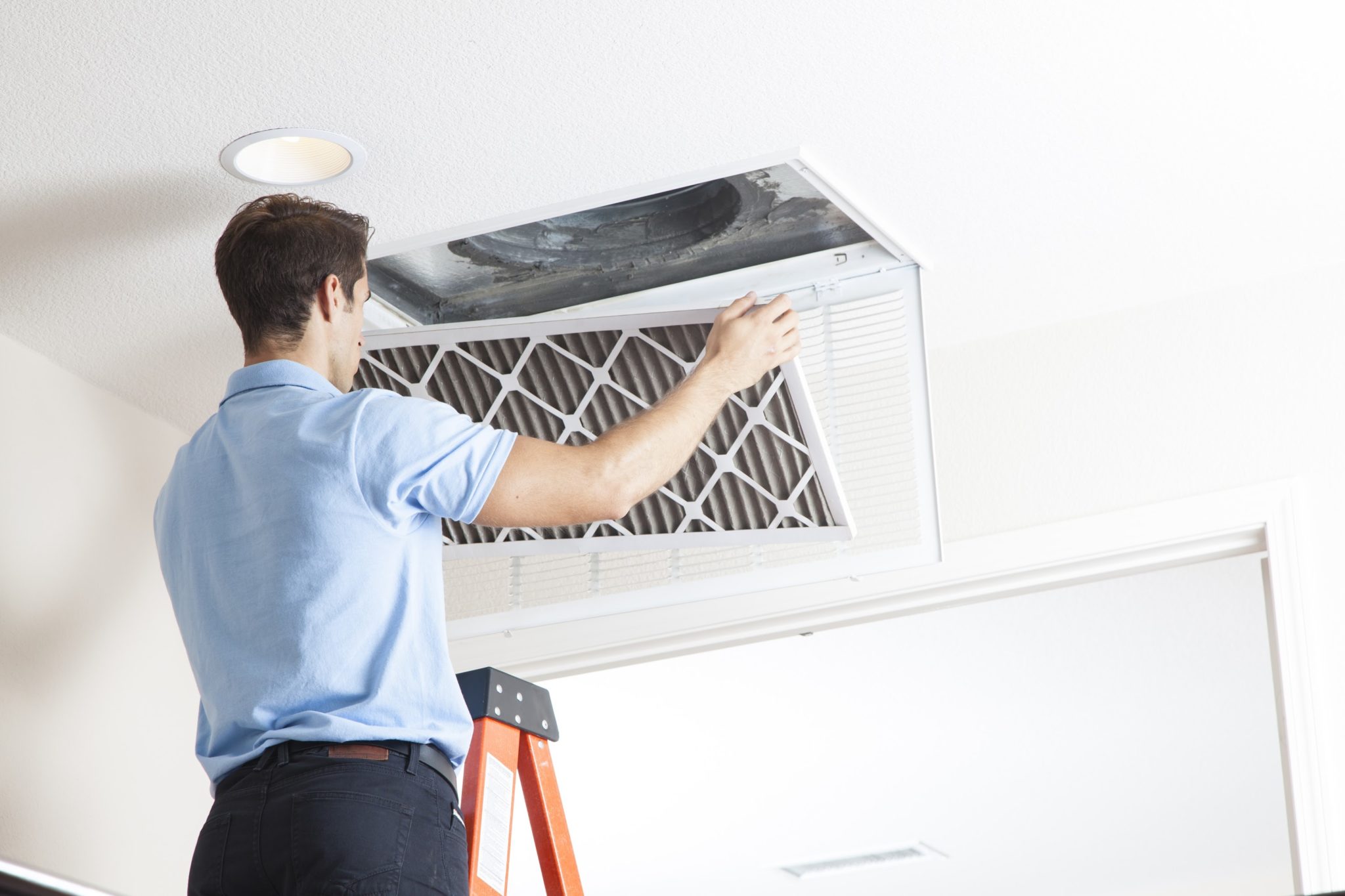 man cleaning air ducts in home.